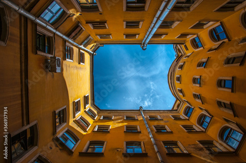 Old historical yellow building and courtyard in the city, Saint Petersburg, Russia, view from bottom to top