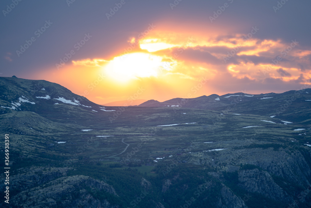 Powerful and explosive sunset with vivid colors over remote mountain road in norway.