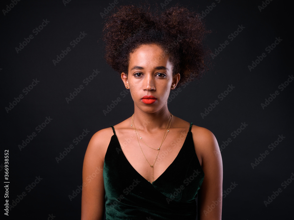 Young beautiful African woman with Afro hair against black background Young beautiful African woman with Afro hair against black background