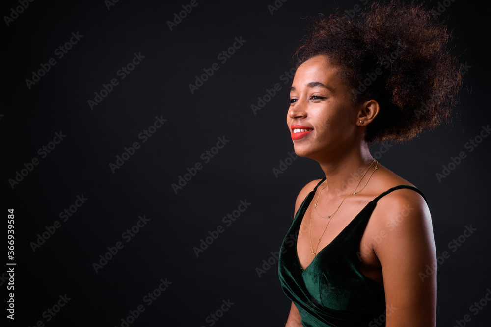 Young beautiful African woman with Afro hair against black background Young beautiful African woman with Afro hair against black background