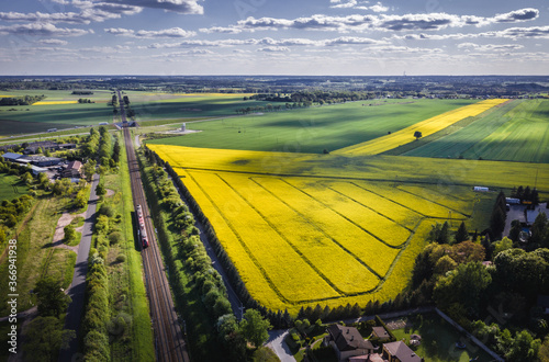 Drone view above railway tracks among fields in Rogow village, Lodz Province of Poland