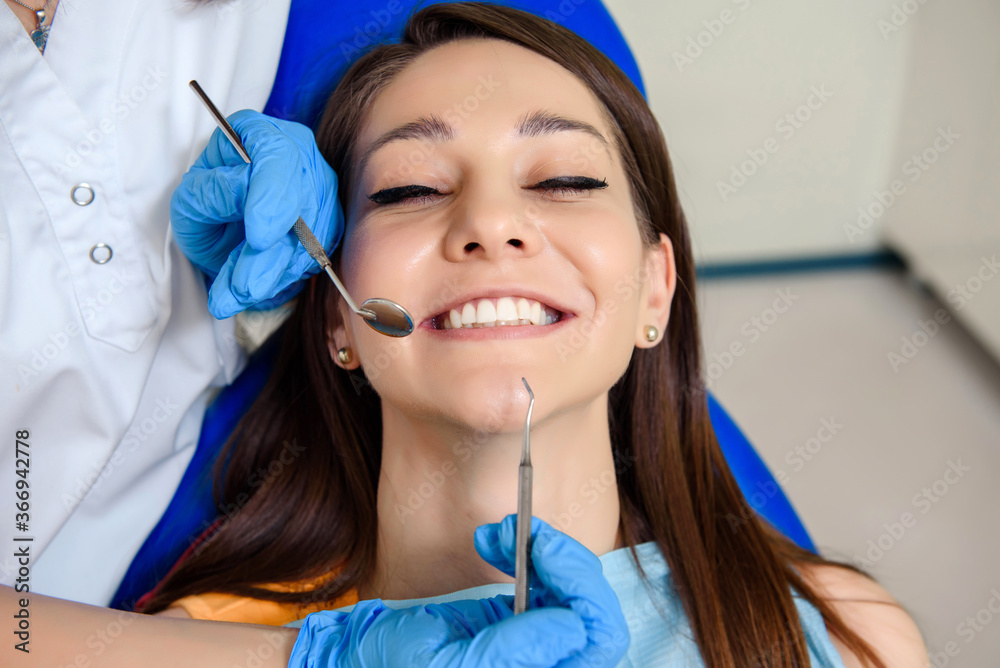 Dentist hands with dental instruments examination patient's teeth in medical clinic Dentist hands with dental instruments examination patient's teeth in medical clinic