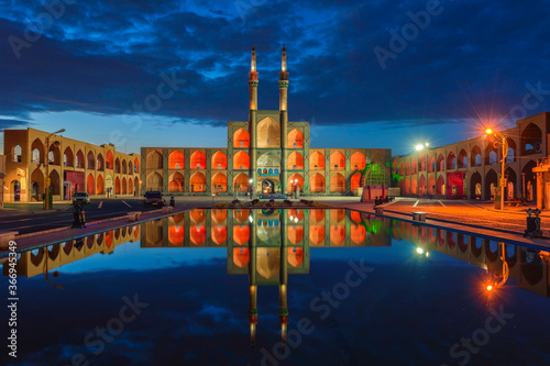 Amir Chaqmaq complex facade illuminated at sunrise and reflecting in a pond, Yzad, Yazd province, Iran