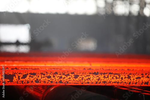Red hot steel metal billets after molten steel casting. Continuous casting machine. Background of the blacksmith and metallurgical industry.