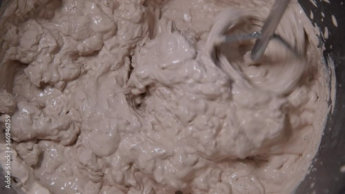 Slow motion pan shot of mixing concrete plaster with electric mixer. spatula and bucket with mortar on the construction site.
