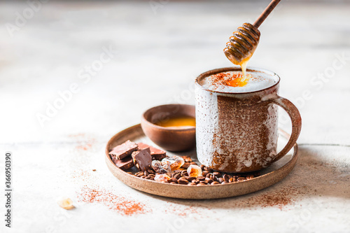 Cappuccino or latte with honey in ceramic dishes. Coffee with milk foam.