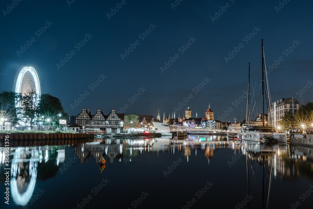 Fototapeta premium Night landscape of bridge over the river with old town in bakground, and a ferriswheel