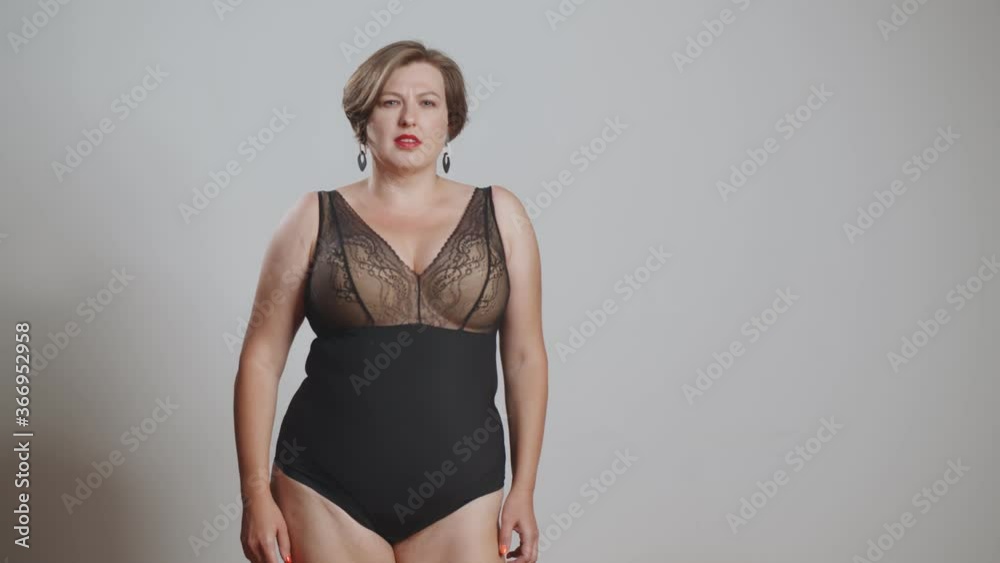 Young beautiful plus size model with stylish haircut and makeup in underwear