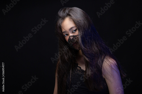 asian girl in black protective mask. Trendy elegant glamour accessory decorated with beads. New normal future. Fashion portrait. graphic make-up arrows. mysterious dramatic transparent lace