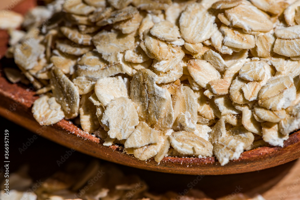 Dry rolled oat flakes oatmeal on old wooden table Dry rolled oat flakes oatmeal on old wooden table