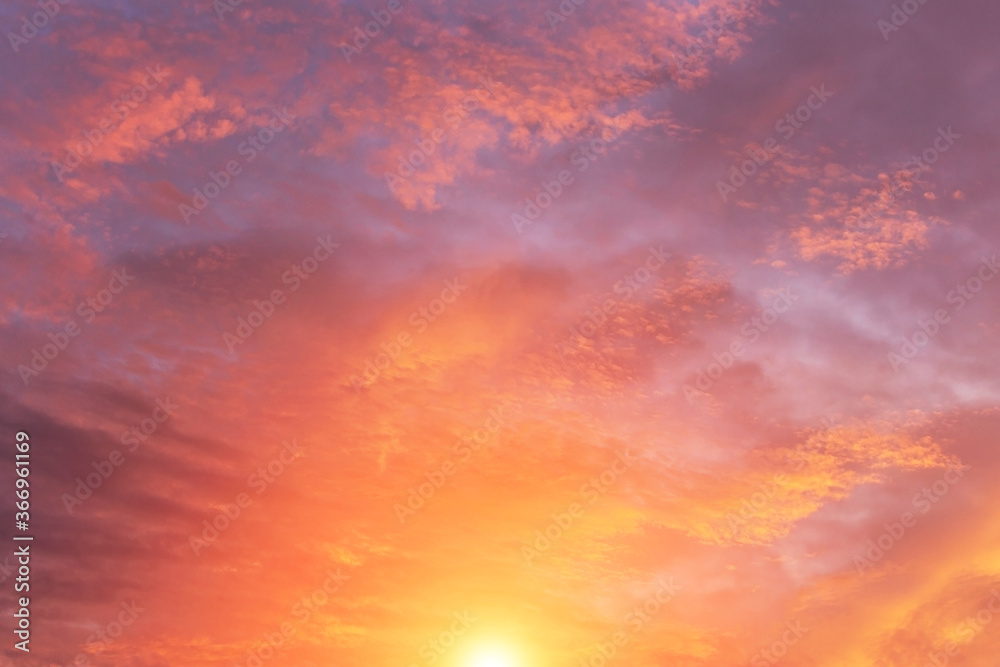 Dramatic soft sunrise, sunset with orange sun and sunlight, pink violet sky with clouds background texture