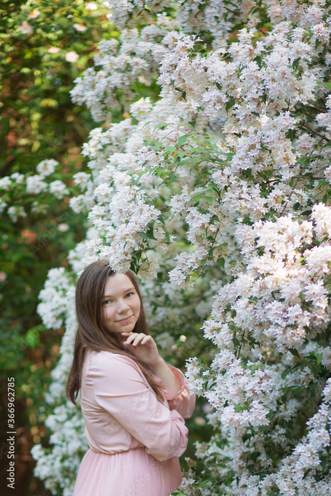 Pregnant woman in the apple orchard is holding tummy and apple blossoming branch Pregnant woman in the apple orchard is holding tummy and apple blossoming branch