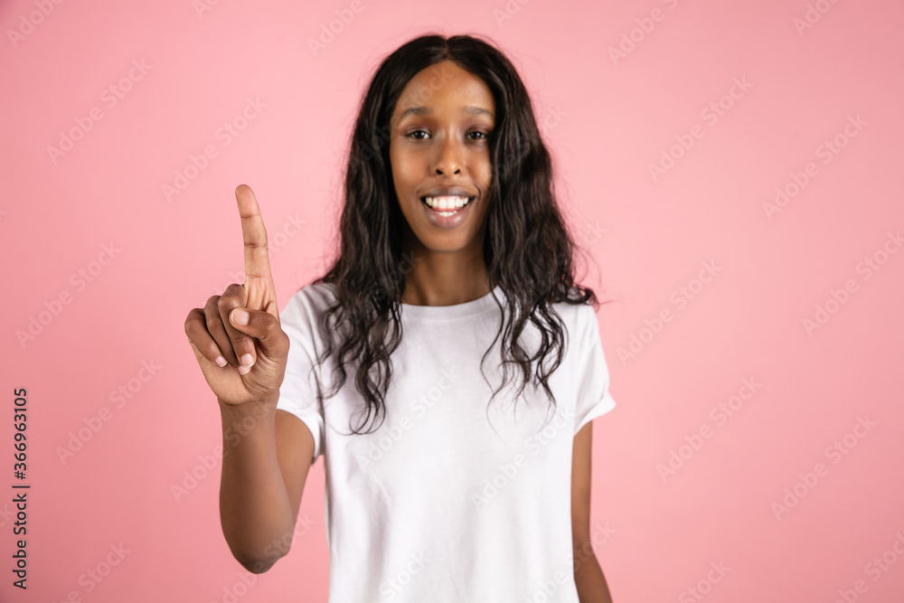 Touching search bar. Cheerful african-american young woman isolated on pink background, emotional. Concept of human emotions, facial expression, sales, ad. Beautiful model with long curly hair. Touching search bar. Cheerful african-american young woman isolated on pink background, emotional. Concept of human emotions, facial expression, sales, ad. Beautiful model with long curly hair.