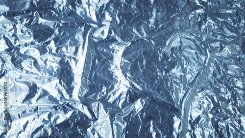 Abstract background. Heart shape in the middle of a crumpled aluminum foil.