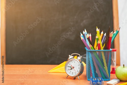 school still life, alarm clock, stand for pencils on the background of a school board, university, college, copy space