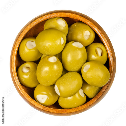 Fotografie Green olives stuffed with garlic cloves in wooden bowl