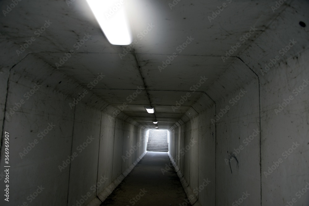 Passage souterrain réservé aux piétons éclairé par des néons
