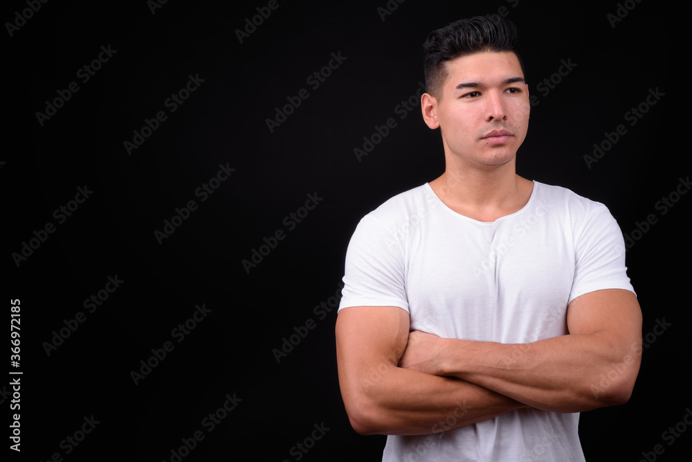 Young handsome multi ethnic man against black background Young handsome multi ethnic man against black background
