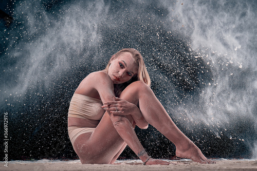 Fototapeta Naklejka Na Ścianę i Meble -  dancing girl in flour (powder). Black studio. Ballet dance.