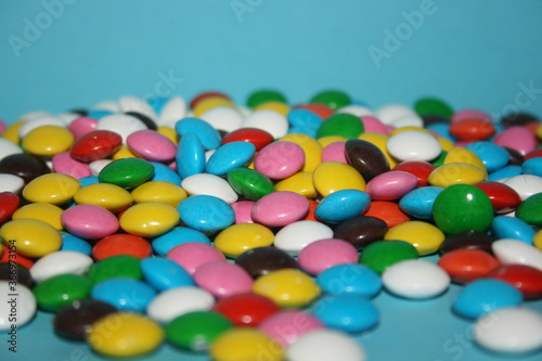 multicolored delicious candies with chocolate on a blue background