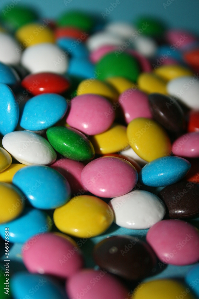 multicolored delicious candies with chocolate on a blue background multicolored delicious candies with chocolate on a blue background