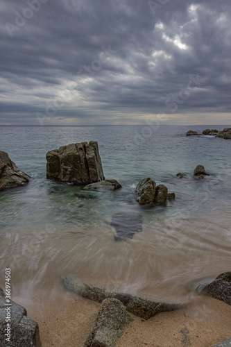 rocas en la orilla del mar a ultima hora del dia con un cielo cargado