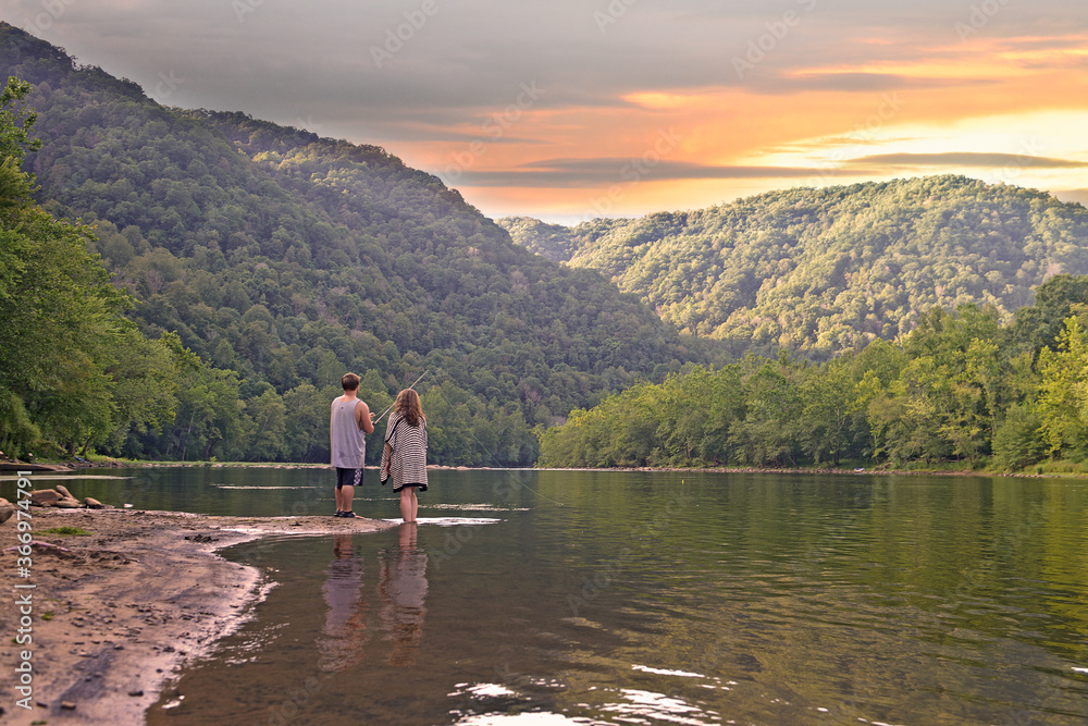 Couple Looking into Sunset over Mountain Range Couple Looking into Sunset over Mountain Range