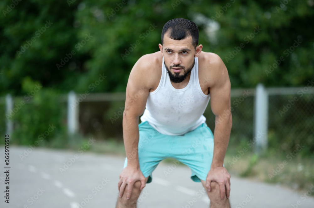 Obraz premium Man was tired after training. The athlete regains his breath