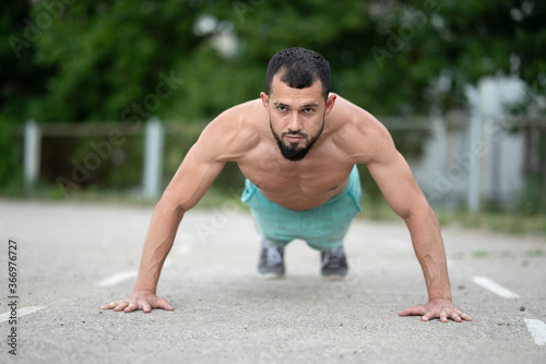 A young athlete does push-UPS. Sports, fitness, street workout concept