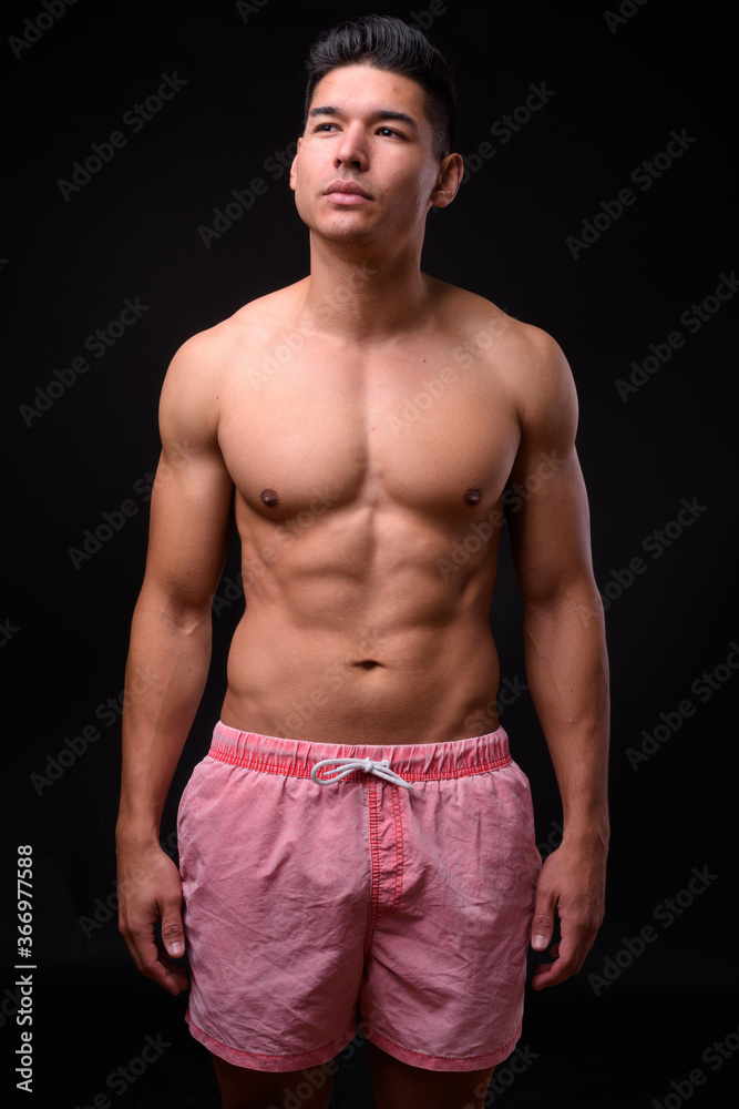 Fototapeta premium Young handsome muscular man shirtless against black background