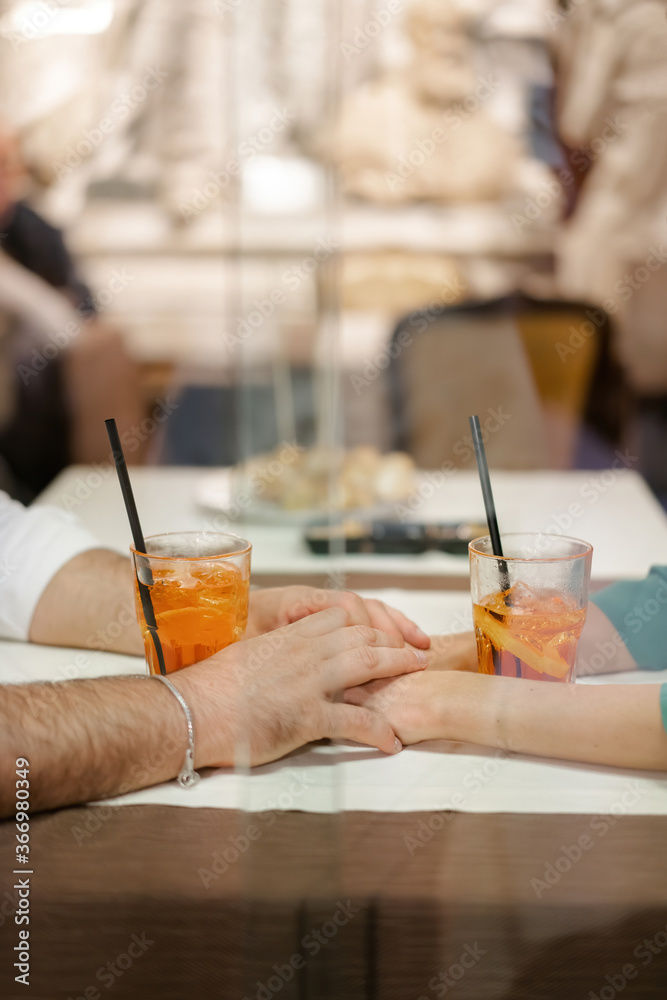 A man and woman couple enjoy a cold orange alcoholic beverage with plastic tubes and piles of ice. Relaxing in a cafe in the summer in the hot heat A man and woman couple enjoy a cold orange alcoholic beverage with plastic tubes and piles of ice. Relaxing in a cafe in the summer in the hot heat