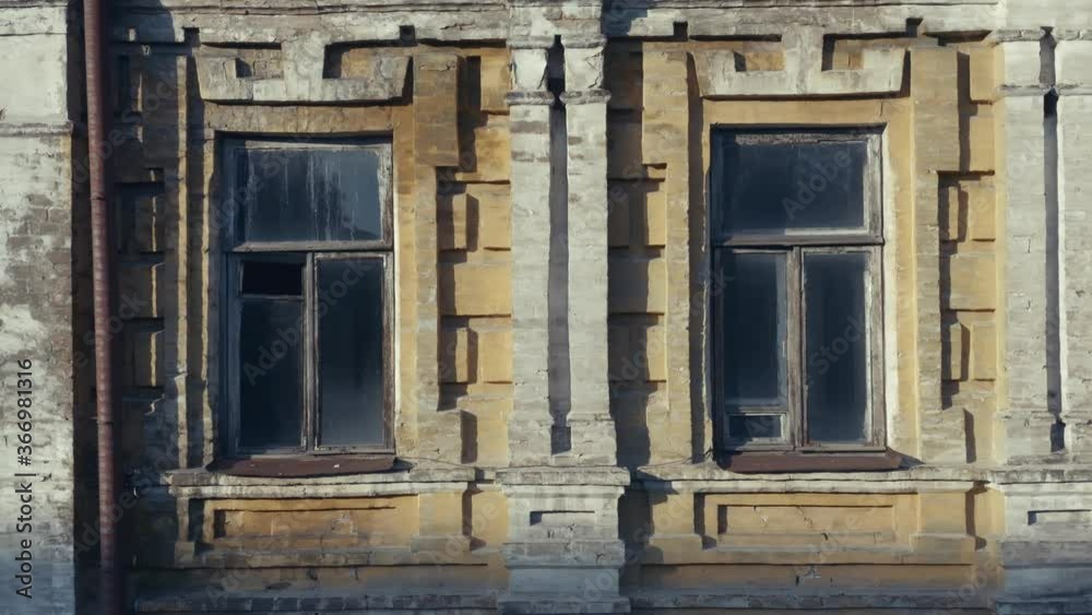 Broken windows in an abandoned old manor (mansion) house. Deserted 19th century building. Aerial side view. Close-up shot Broken windows in an abandoned old manor (mansion) house. Deserted 19th century building. Aerial side view. Close-up shot