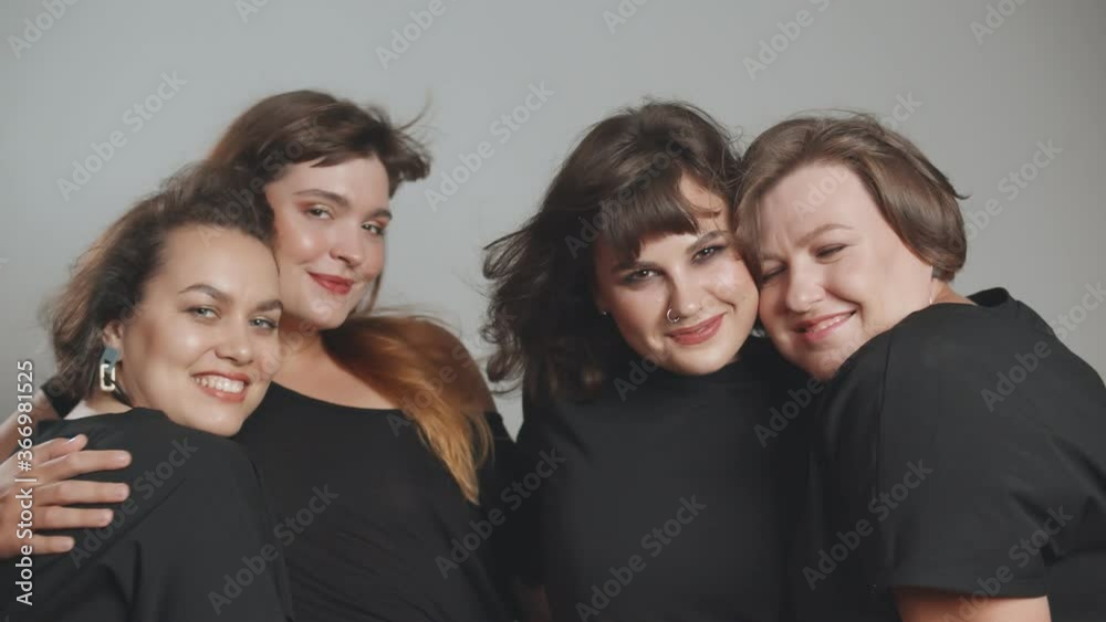 Close up of beautiful plus size young women posing on grey background.