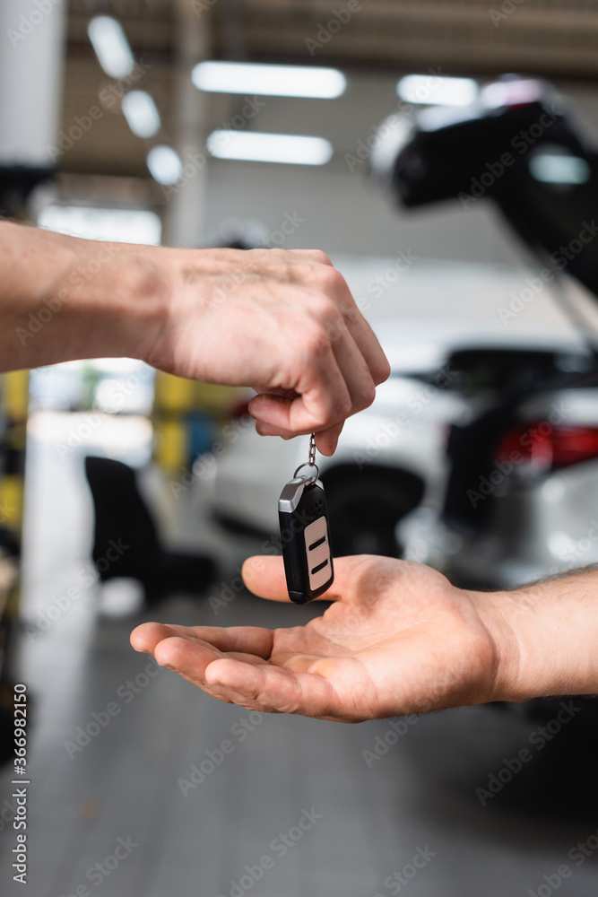 Fototapeta premium Selective focus of man receiving car key at service station