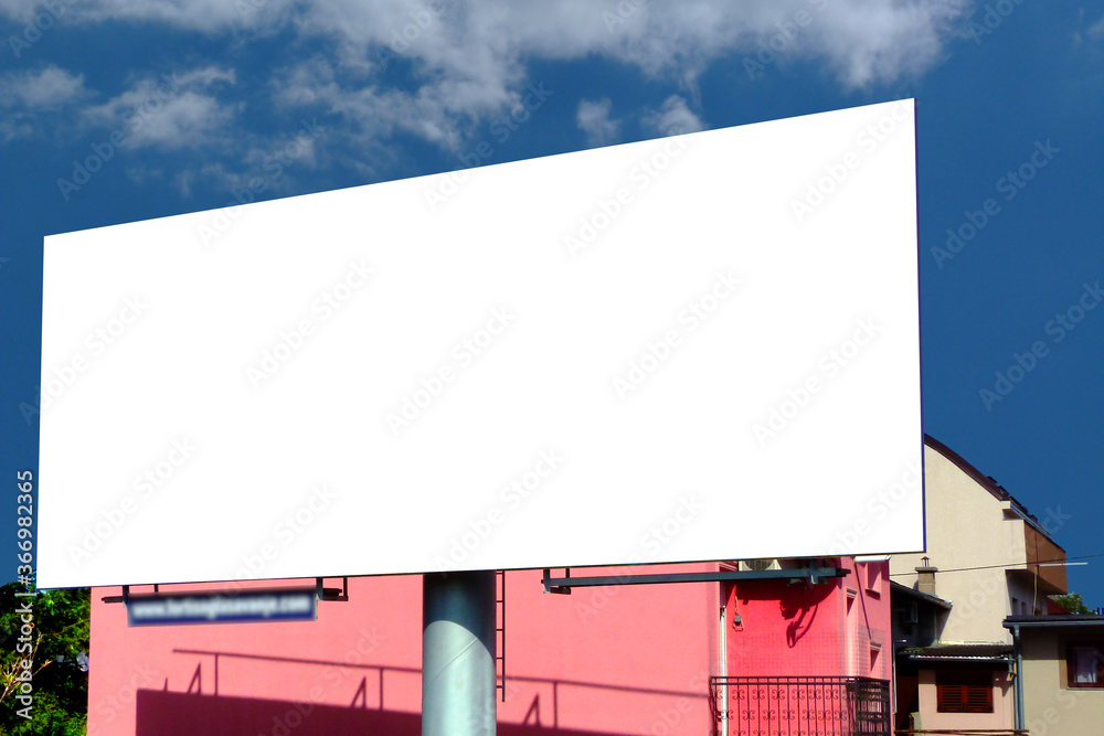 Large billboard ad panel in urban residential setting with blue sky and white clouds background. blank white image template for mockup. horizontal ad template Large billboard ad panel in urban residential setting with blue sky and white clouds background. blank white image template for mockup. horizontal ad template