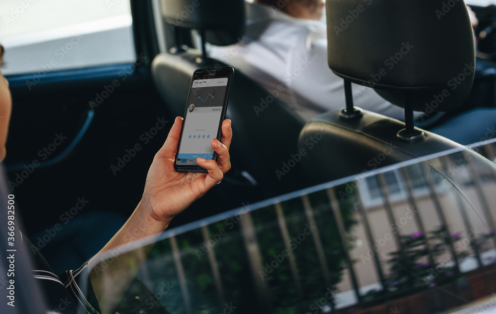 Woman travelling by a taxi looking at her phone Woman travelling by a taxi looking at her phone