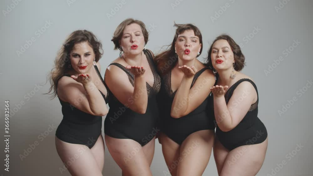 Stylish charming plus size models sending air kisses posing at camera