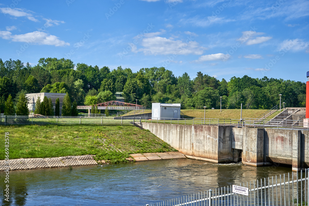 Fototapeta premium Small dam on the river with fence around it 