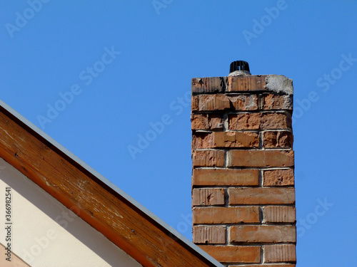 Fototapeta Isolated clay brick chimney with weathered and spalling surface