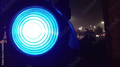 Railway semaphore lighting blue at foggy evening in the suburbs. Lights, people, trucks, transport interchange. photo