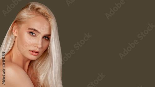 Beauty portrait. Skincare wellness. Blonde woman with natural makeup bare shoulder isolated on brown empty space.
