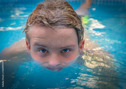 yong man with amazing blue eyes in swimming pool ,enjoying his holiday .