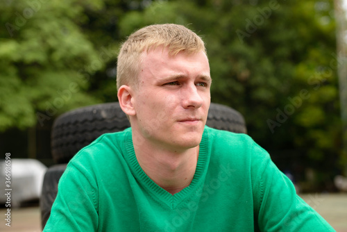 Portrait of young man with blond hair outdoors