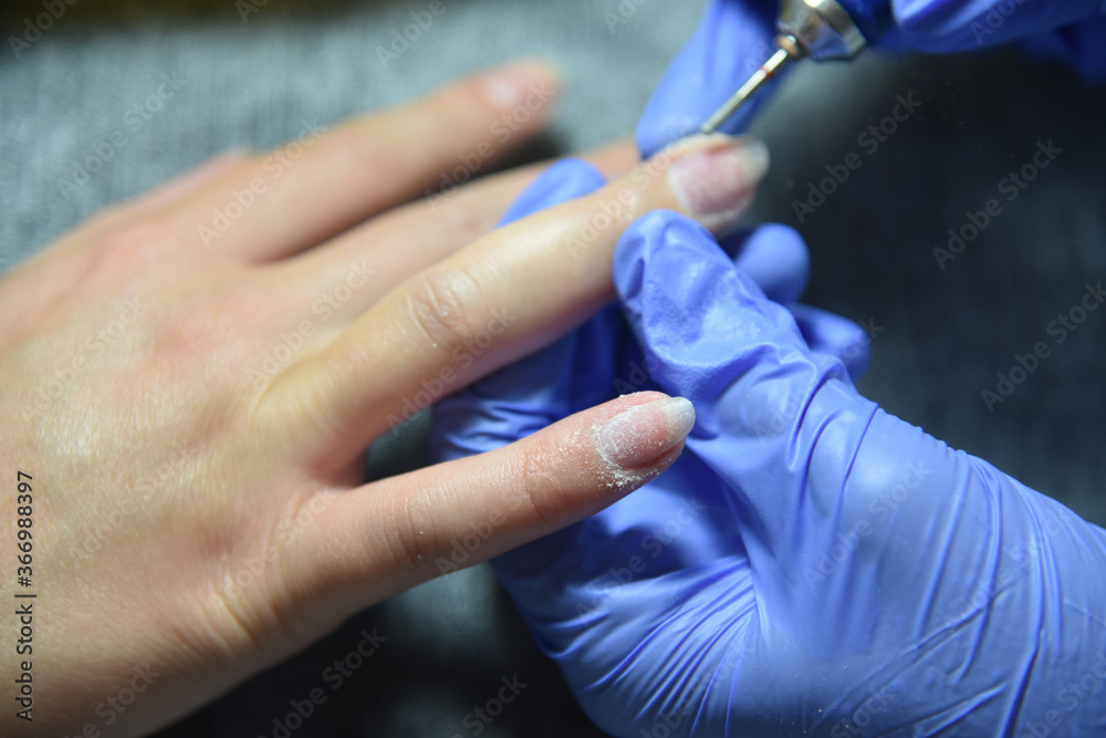 A manicure procedure in the beauty saloon, transparent nail polish A manicure procedure in the beauty saloon, transparent nail polish