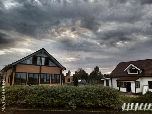 Fototapeta Naklejka Na Ścianę i Meble -  houses on the hill on a dark clouds