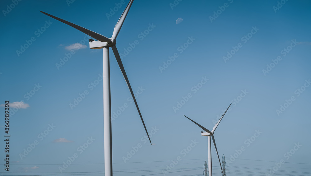 Wind turbine on blue sky with moon Wind turbine on blue sky with moon