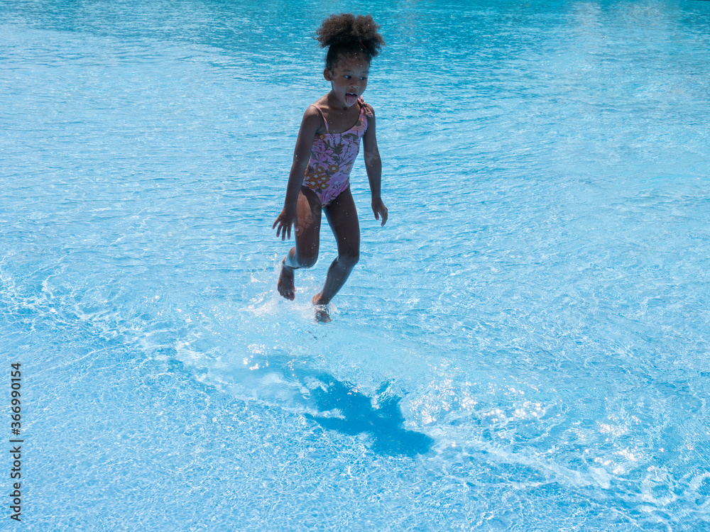Summer season. African American girls having fun on the swimming pool in aqua park at the day time. Fun and summer lifestyle