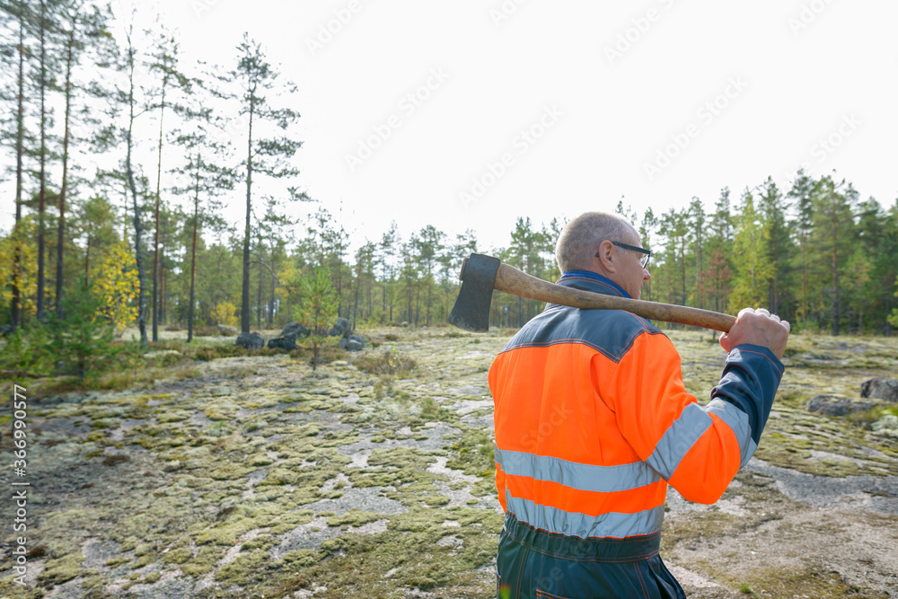 Portrait of mature handsome man holding ax in the forest Portrait of mature handsome man holding ax in the forest