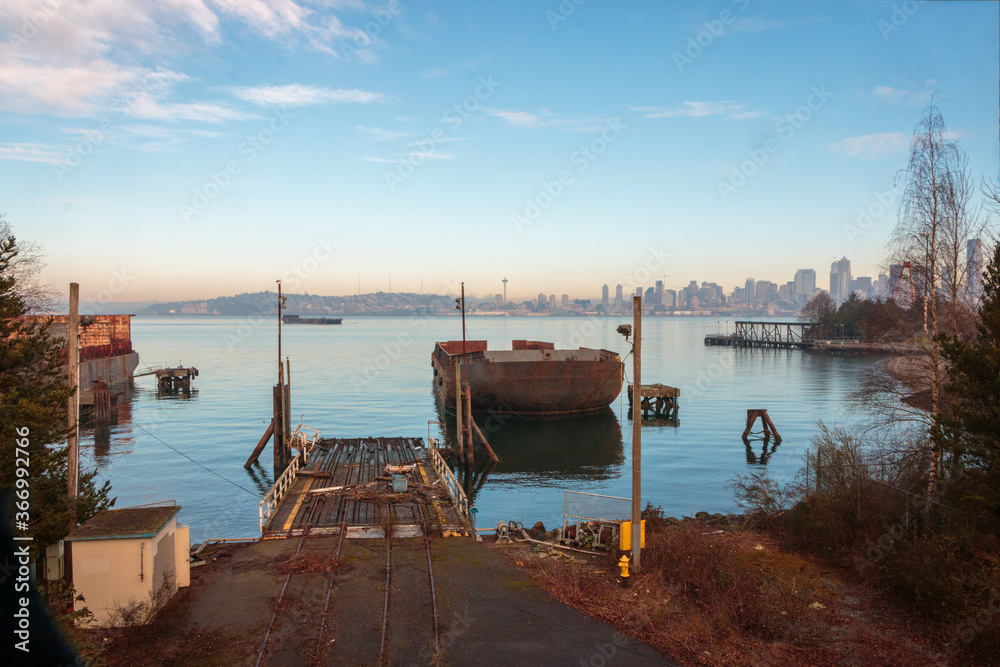 Rusty barge foreground with Seattle skyline background blue sky day