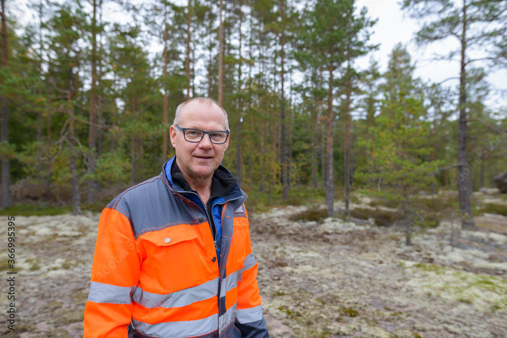 Portrait of happy mature handsome man standing in the forest Portrait of happy mature handsome man standing in the forest